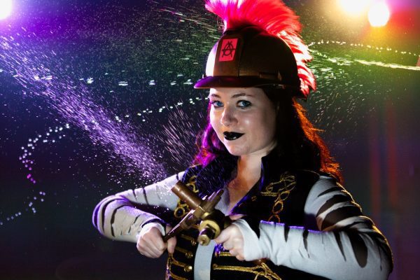 An image of a woman wearing a Roman style hat and holding a tool.
