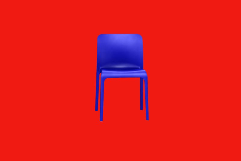 A blue chair against a red background.
