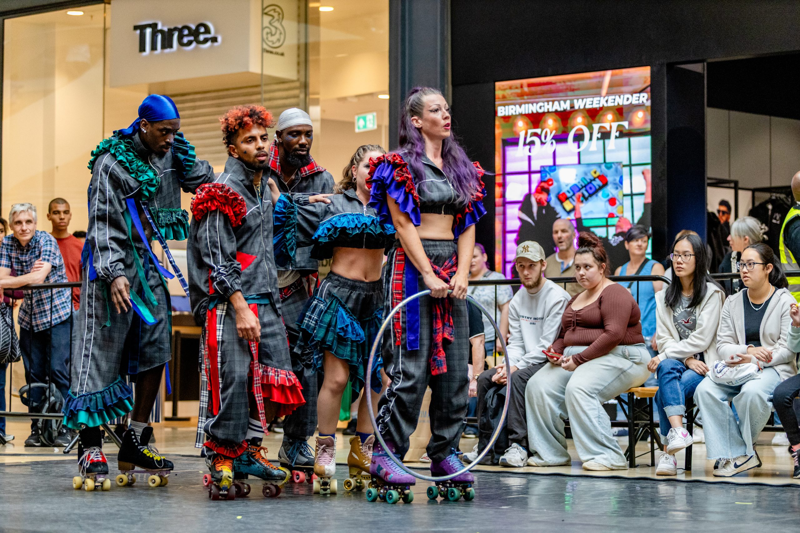 An image of a group of performers wearing roller skates performing in a shopping centre